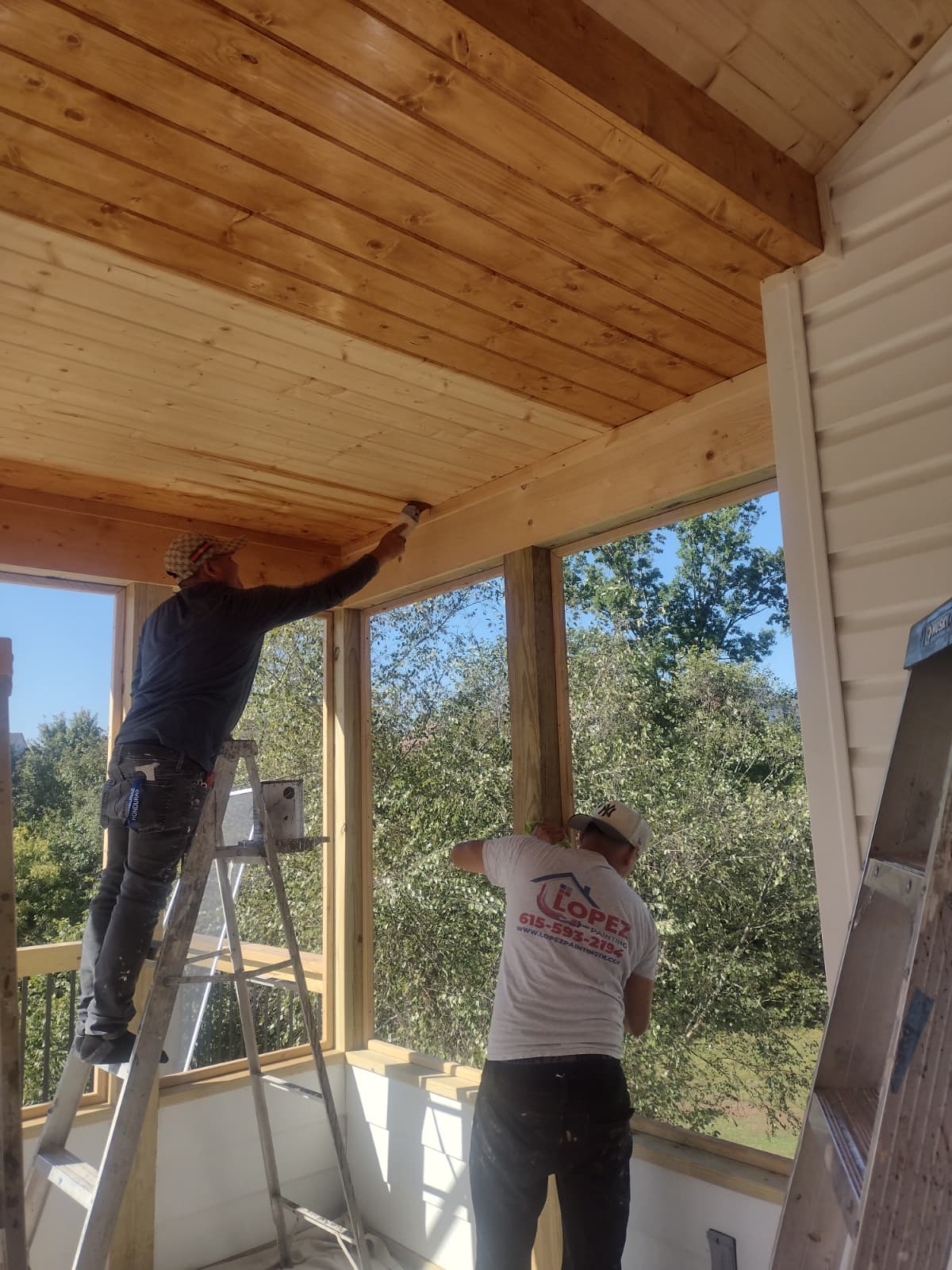Marco's crew at work — Lopez Painting branded shirts, working on a Nashville home porch